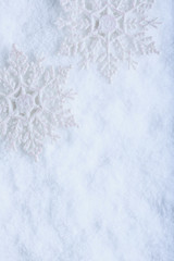 Fototapeta na wymiar Two beautiful sparkling vintage snowflakes on a white frost snow