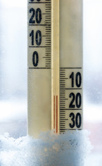 Thermometer in snow marks temperatures below zero. Selective focus.