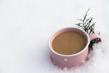 cappuccino in a pink cup on the snow