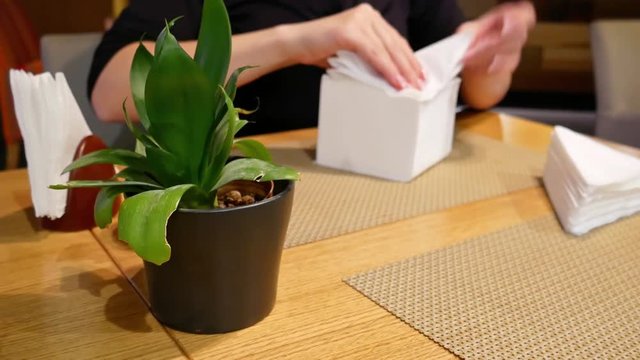 Female hands folding a lot of napkins.