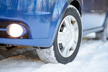 Blue Car with Winter Tires on the Snowy Road. Drive Safe.