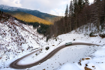 The movement of the car on a mountain road. / The car in the winter riding down the mountain winding road. The road to the mountain Dragobrat, Western Ukraine.