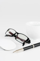 cup of coffee, pen, mouse and glasses, on a background