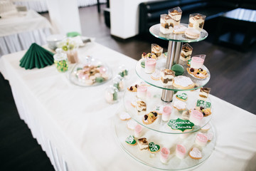 Wedding reception candy bar dessert table. Delicious sweet buffet with cupcakes. Sweet holiday buffet 