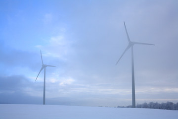 Wind turbine in winter at fog