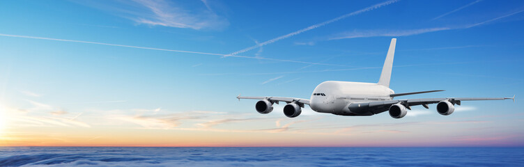 Fototapeta na wymiar Huge airplane flying above clouds in dramatic sunset