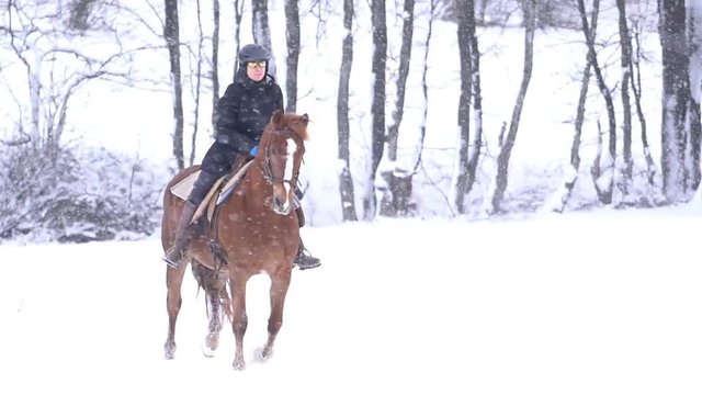 slow motion woman on galloping horse in snow
