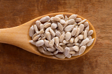 Sunflower seed in wooden spoon on wooden background.
