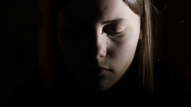 2Depressed teen girl is scared by something in the dark. 4K UHD.