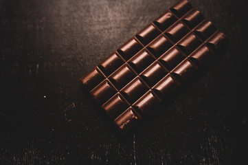 chocolate on wooden table on dark background