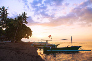 beautiful beach in Bali at sunset, exotic landscape with boats and palm trees