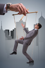 Businessman puppet being manipulated by boss