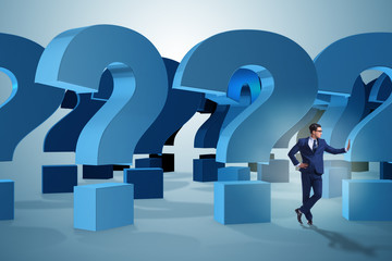 Businessman in uncertainty concept with question marks