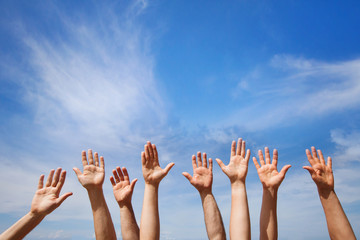 volunteering concept, hands of group of people volunteers in blue sky