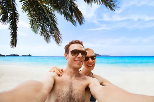 happy young couple taking selfie photo on the beach, self portrait or selfy
