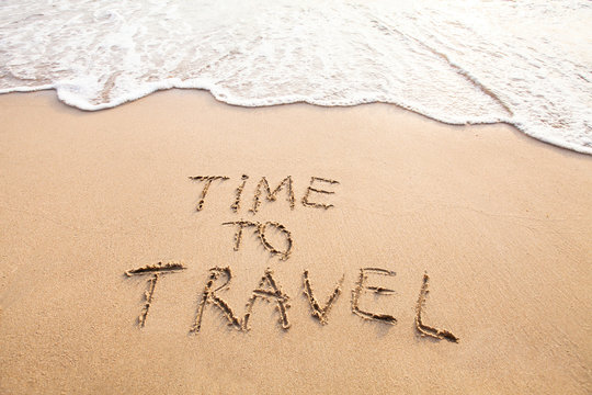 time to travel, concept text drawn on sand of beach