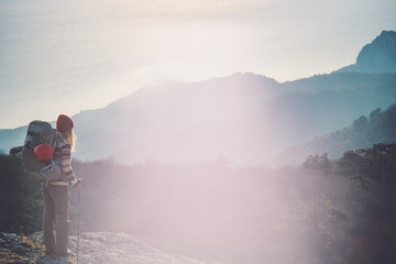 Obraz premium Woman Traveler with backpack hiking on cliff Travel Lifestyle concept adventure active vacations outdoor sunset aerial view from mountain summit on background
