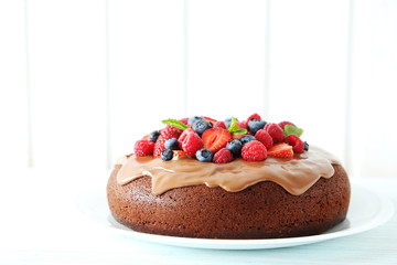 Homemade chocolate cake with berries on white wooden table