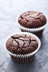 Chocolate muffins on a grey wooden table