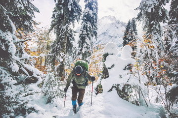 Traveler Man with backpack hiking in winter snowy forest landscape Travel Lifestyle concept...