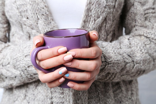 Woman hands with manicure holding cup of coffee