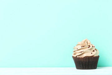 Tasty cupcake on a green background