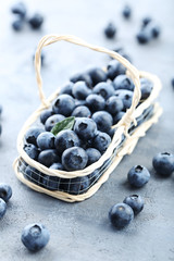 Ripe and tasty blueberries on grey wooden table
