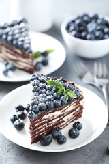 Tasty piece of cake with blueberries on wooden table