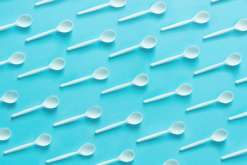 Spoons pattern on blue paper, top view