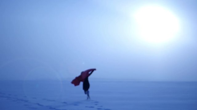 beautiful girl spreading arms runs with a blanket over his back, which develops in the wind, on a background of the sun in the fog, 4k