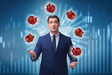 Businessman juggling with piggybanks in business concept