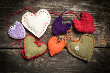 Valentine's Day. Colorful knitted hearts. Red heart on the dark old boards. Valentines day. Heart...