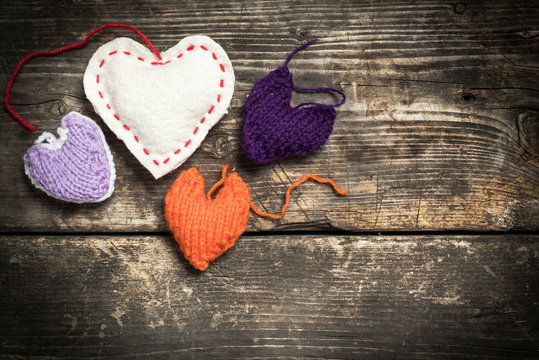 Valentine's Day. Colorful knitted hearts. Red heart on the dark old boards. Valentines day. Heart pendant. Red heart. Valentine cards. Space for text. Eighth of March. International Women's Day.