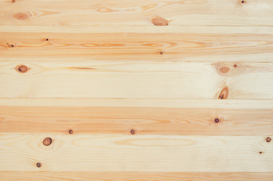 Fresh knotted pine wood planks background top view. Visible texture with natural patterns.