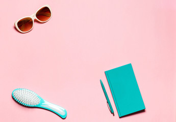 Minimalistic composition of hairbrush and eyeglasses on pink copy space