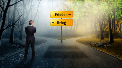 Mann im Anzug steht an Weggabelung zwischen Krieg und Frieden