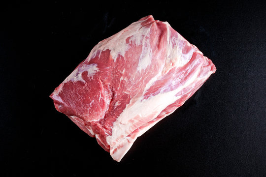 Fresh Raw French Whole Pork Ribeye On Black Board.