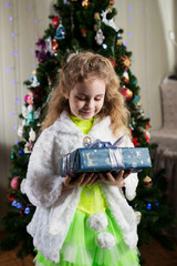 Happy little smiling girl with christmas gift box