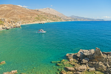 Obraz premium white motor boat at rocky coast