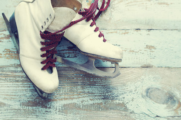 Old white skates for figure skating on a vintage wooden surface
