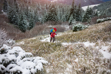 Two women with backpacks in the mountains in winter.