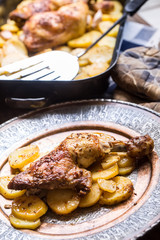 Roasted chicken leg with potatoes with caraway and garlic.