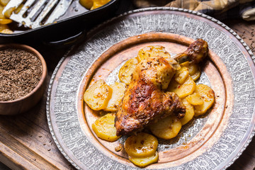 Roasted chicken leg with potatoes with caraway and garlic.