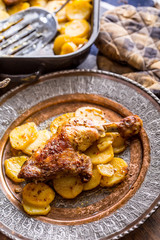 Roasted chicken leg with potatoes with caraway and garlic.
