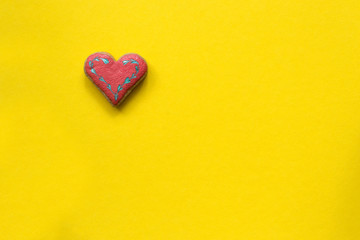 Heart shaped sugar cookie on yellow background. Valentines day card concept.