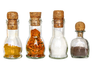 curry, black pepper, salt and paprika in glass bottles with corc