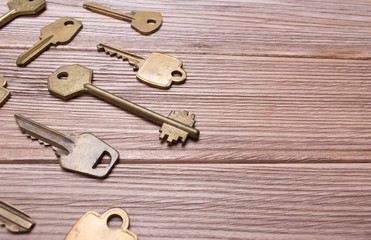 Older different golden keys on a wooden table