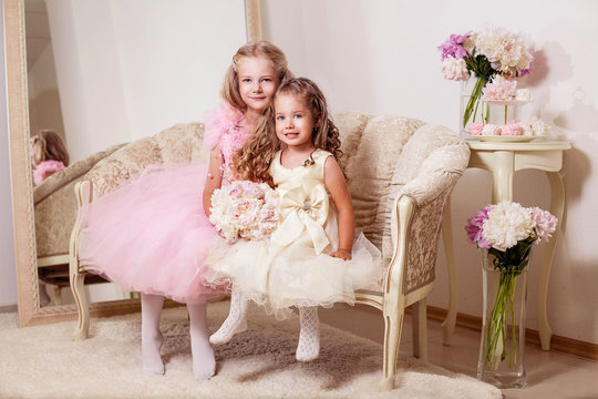 Happy smiling flower girls with peony bouquet and sweets. Wedding. Trinity. Pentecost.