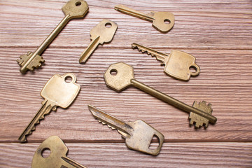 Older different golden keys on a wooden table