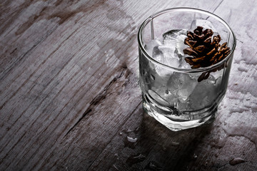 glass with ice on a wooden background